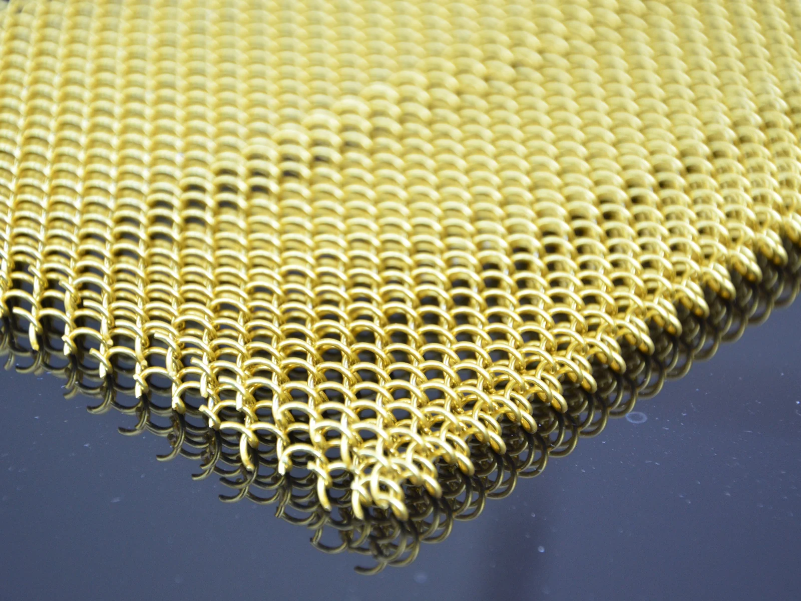 Interlocking coils forming a flexible metal drapery sample