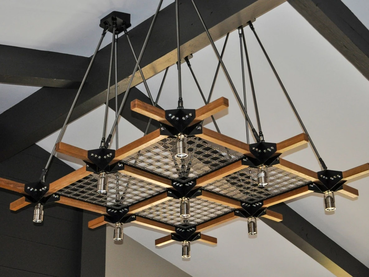 Woven metal mesh panels within a suspended timber and metal lighting feature