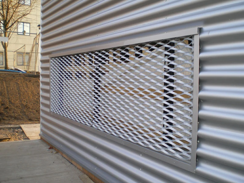 Framed expanded metal panel set into a corrugated exterior wall
