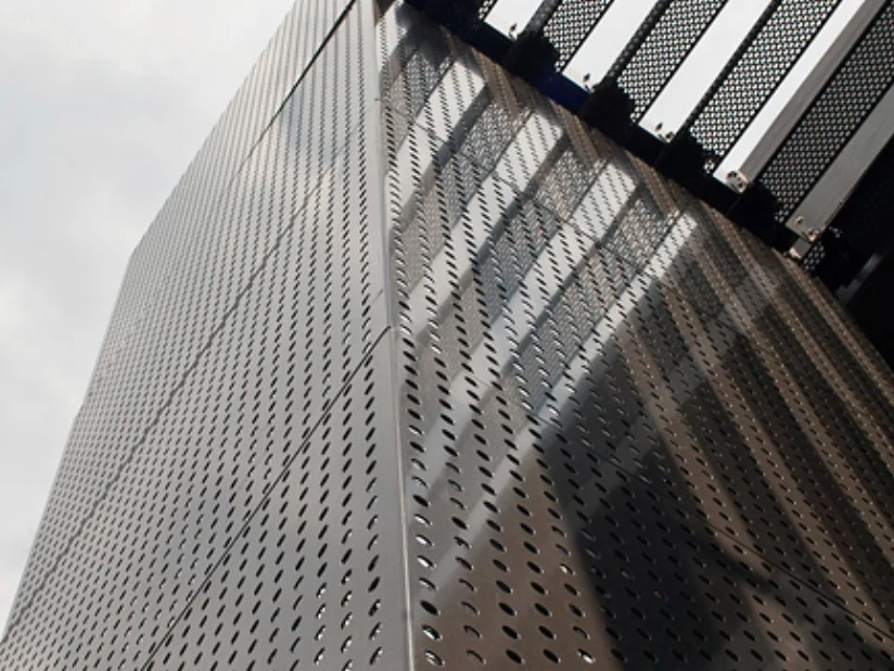 Perforated metal cladding beneath the glazed upper level of a building facade