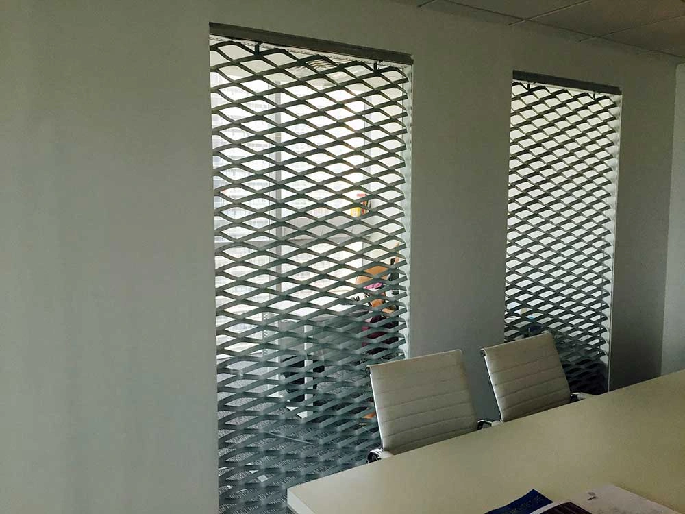 Expanded metal screens installed within interior wall openings beside a meeting table
